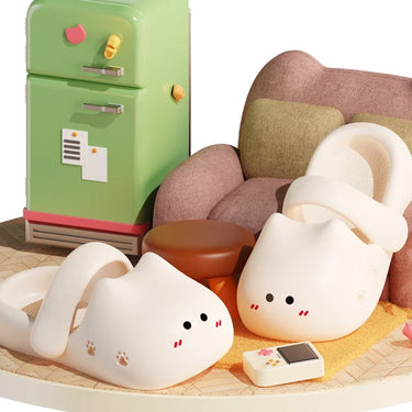 KittyNook Cat Co. Adorable Cat Face Comfort Sandals with non-slip soles rest by a couch, green fridge, and ottoman.